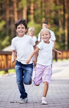 Siblings smiling and running