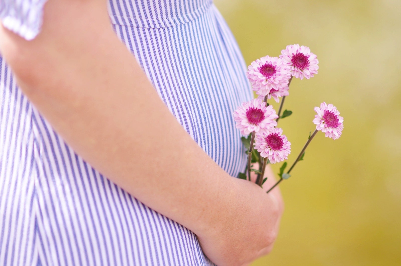 Femme enceinte tenant des fleurs