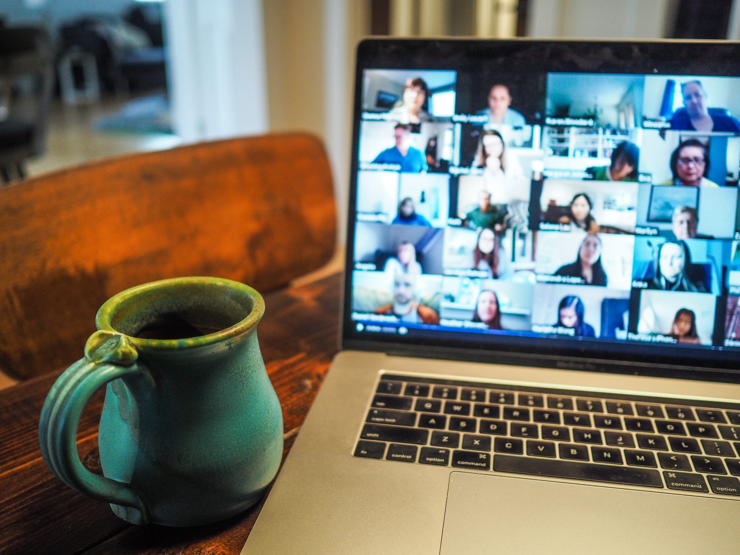 Image of a virtual call on a laptop with a mug beside it.